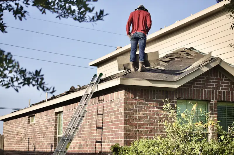 Roofer standing on the roof of a brick home